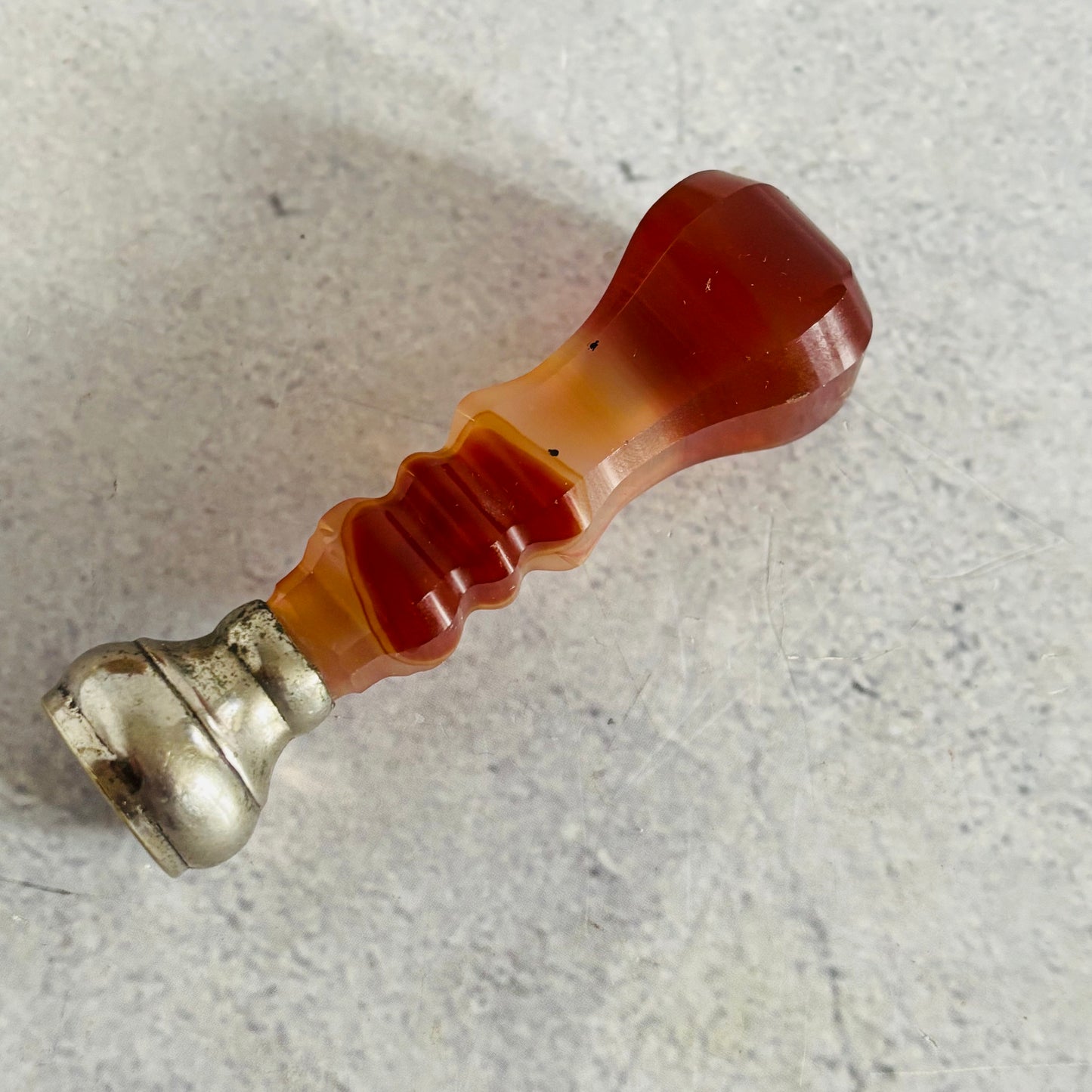 Decorative object with a red and silver design on a textured surface