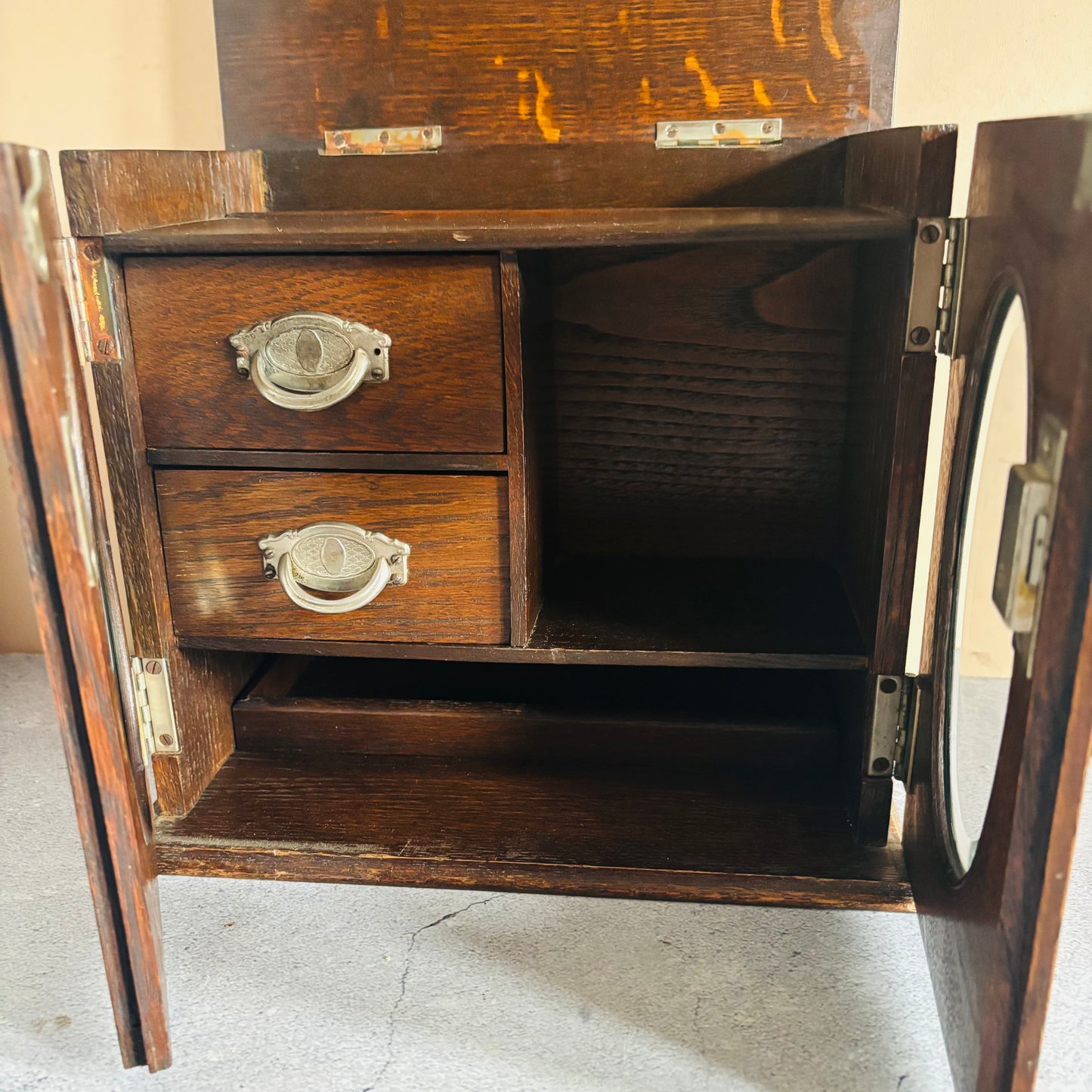 Antique Arts & Crafts Oak Smokers Pipe Cabinet For Storage Or Display with open doors and drawers on a concrete floor.