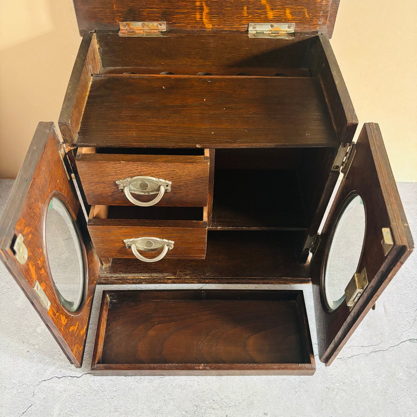 Wooden jewelry box with multiple compartments and drawers on a light background