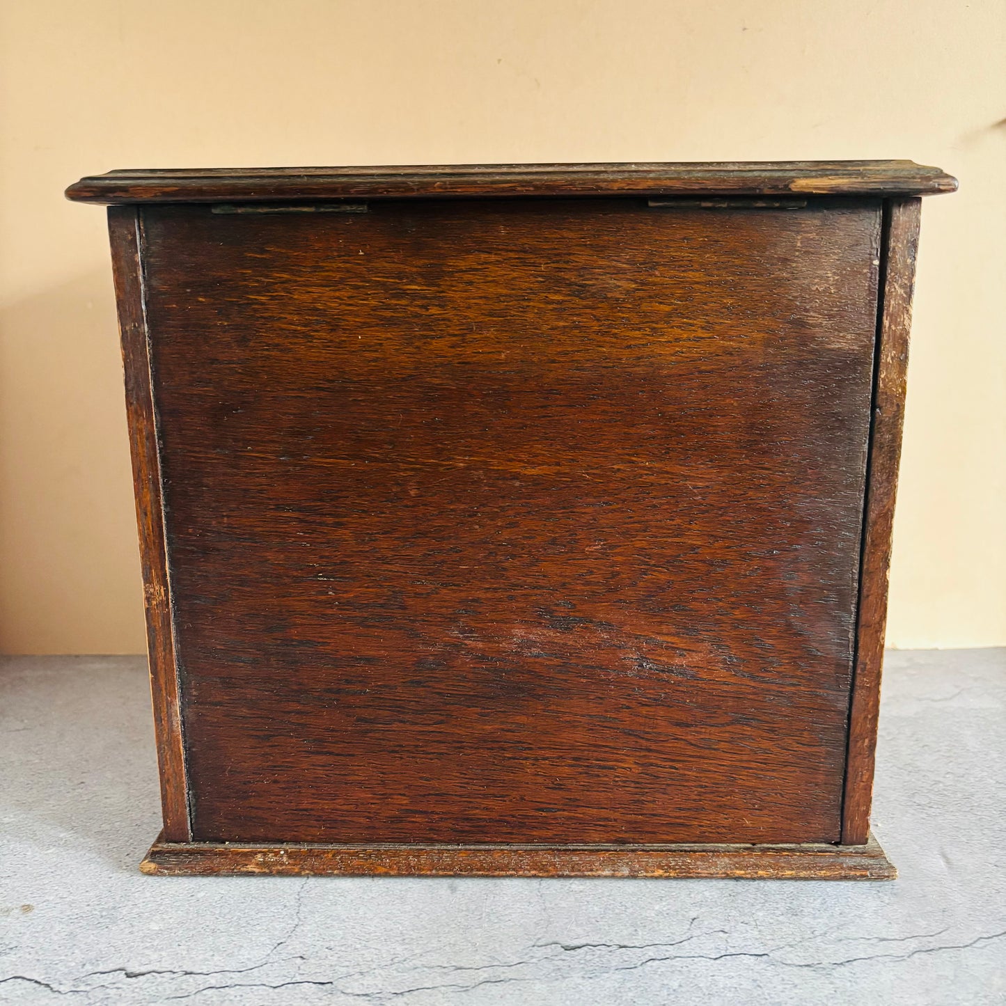 Dark wooden cabinet against a beige wall