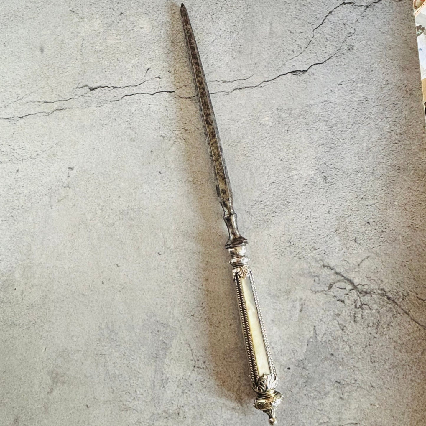 Decorative skewer opener on a textured stone surface