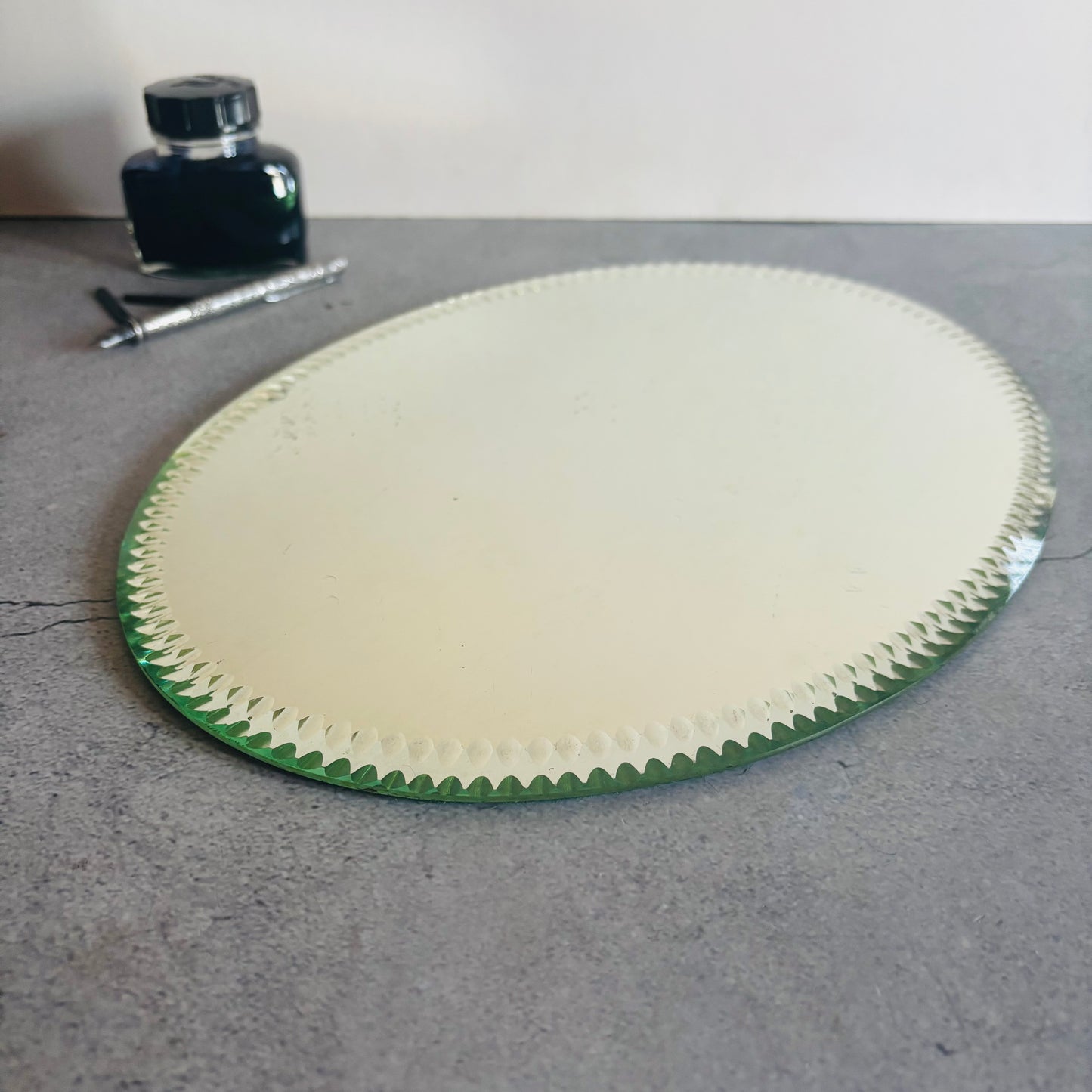 Antique Oval Sorcerers Mirror Mat with ink bottle and pen in the background.