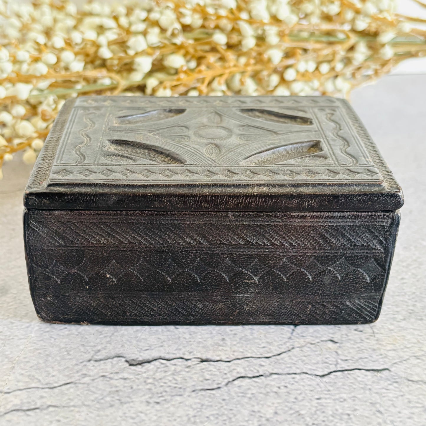 Decorative brown leather box with intricate patterns on a light background