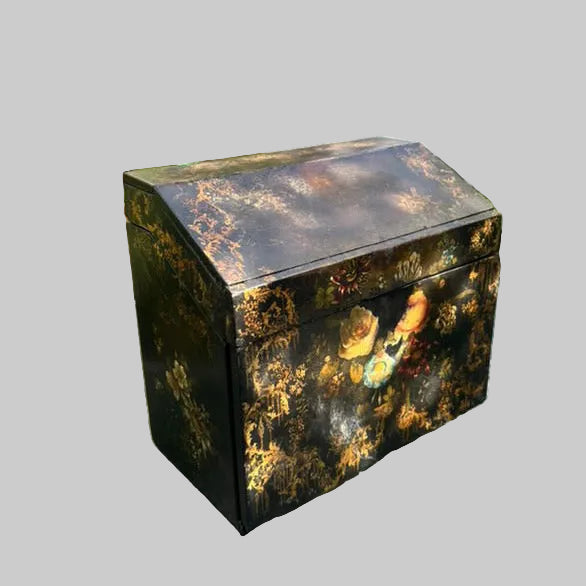 Victorian Paper Mache Lacquer Stationery Box  with hand painted floral patterns on a glass table outdoors.