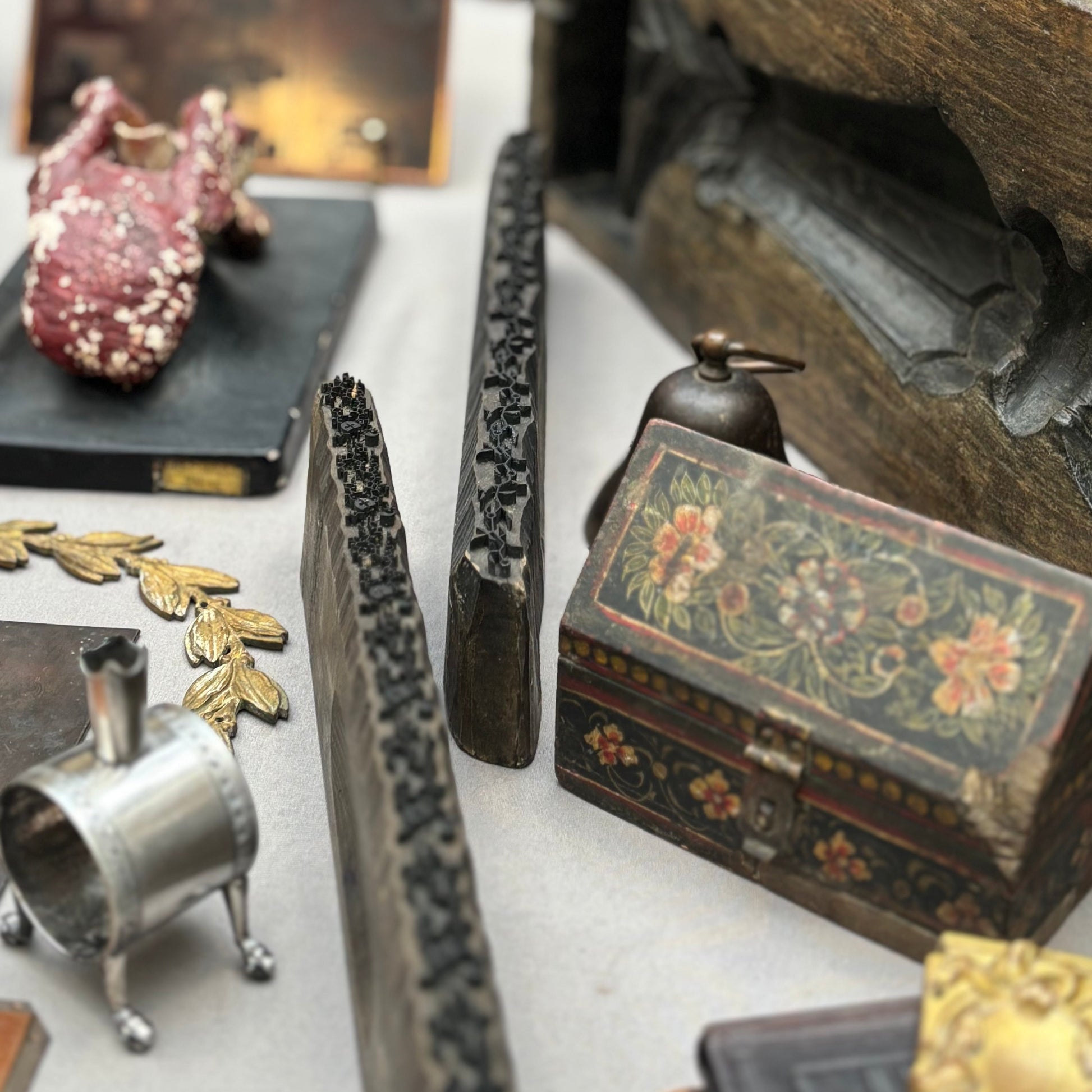 Collection of vintage objects including a small wooden box with floral patterns on a table.