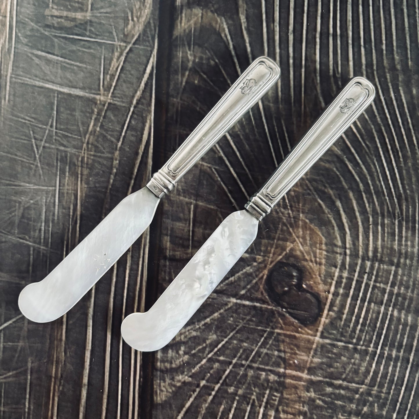 antique Silver & Mother Of Pearl Caviar knives  on a wooden surface