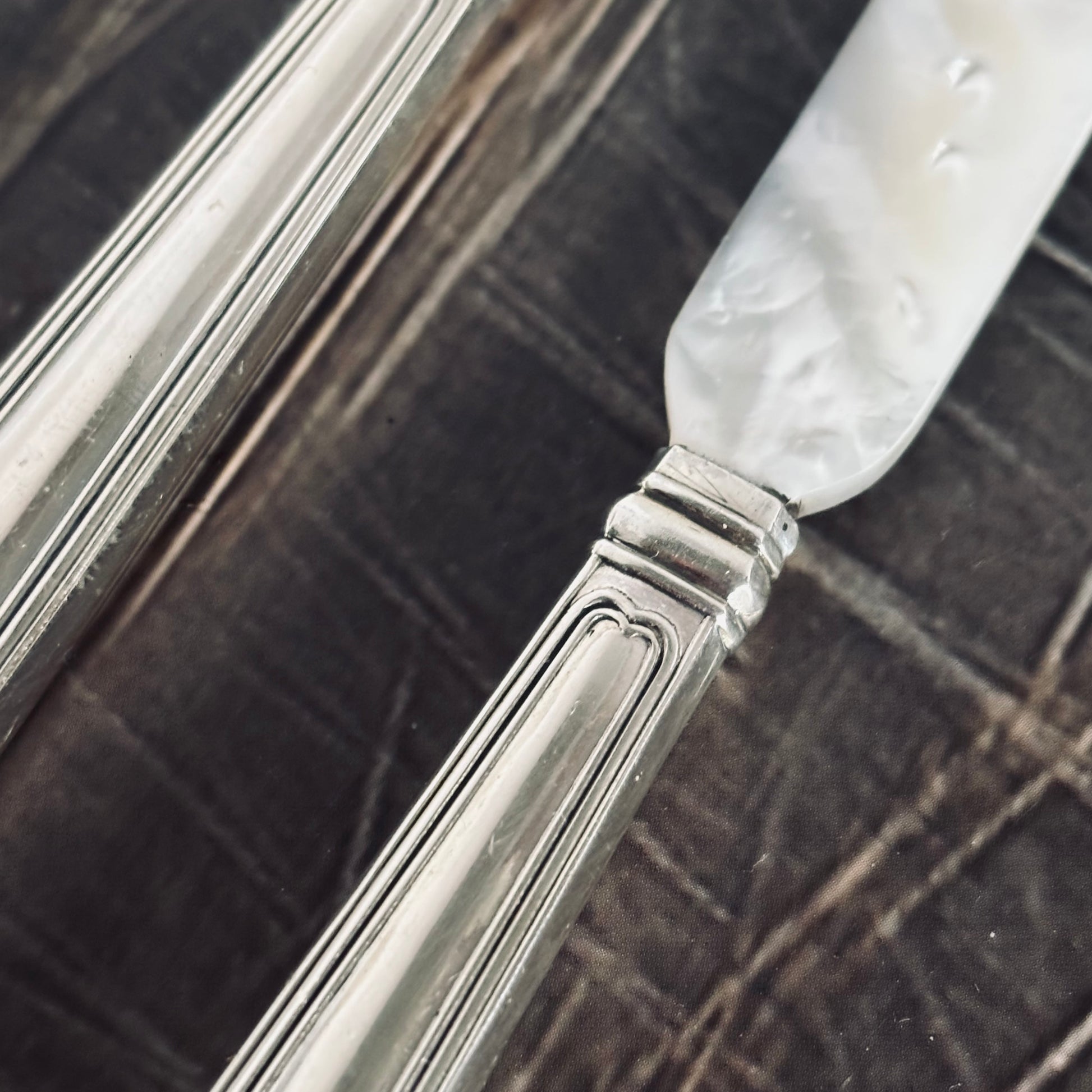 Antique Silver & Mother Of Pearl Caviar knives  on a wooden surface