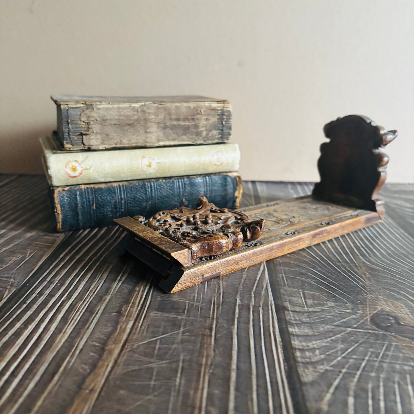 Stack of old books on a wooden surface with a Antique Italian Miniature Book Slide 