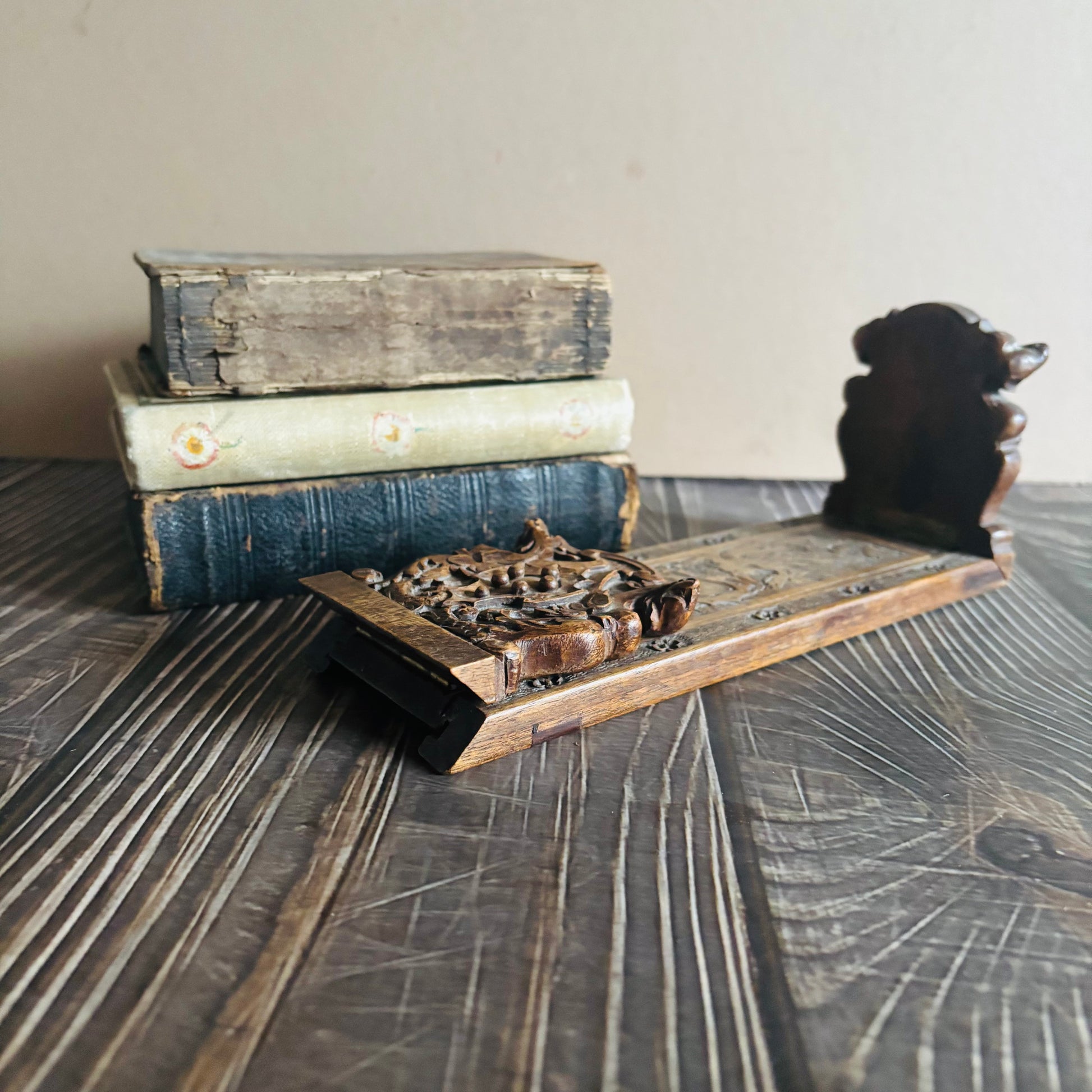 Stack of old books on a wooden surface with a Antique Italian Miniature Book Slide 