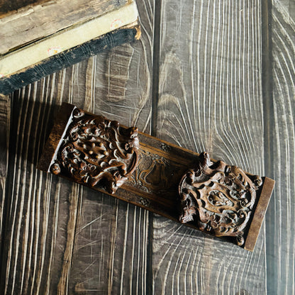 Decorative wooden Antique Book Slide with intricate carvings on a wooden surface
