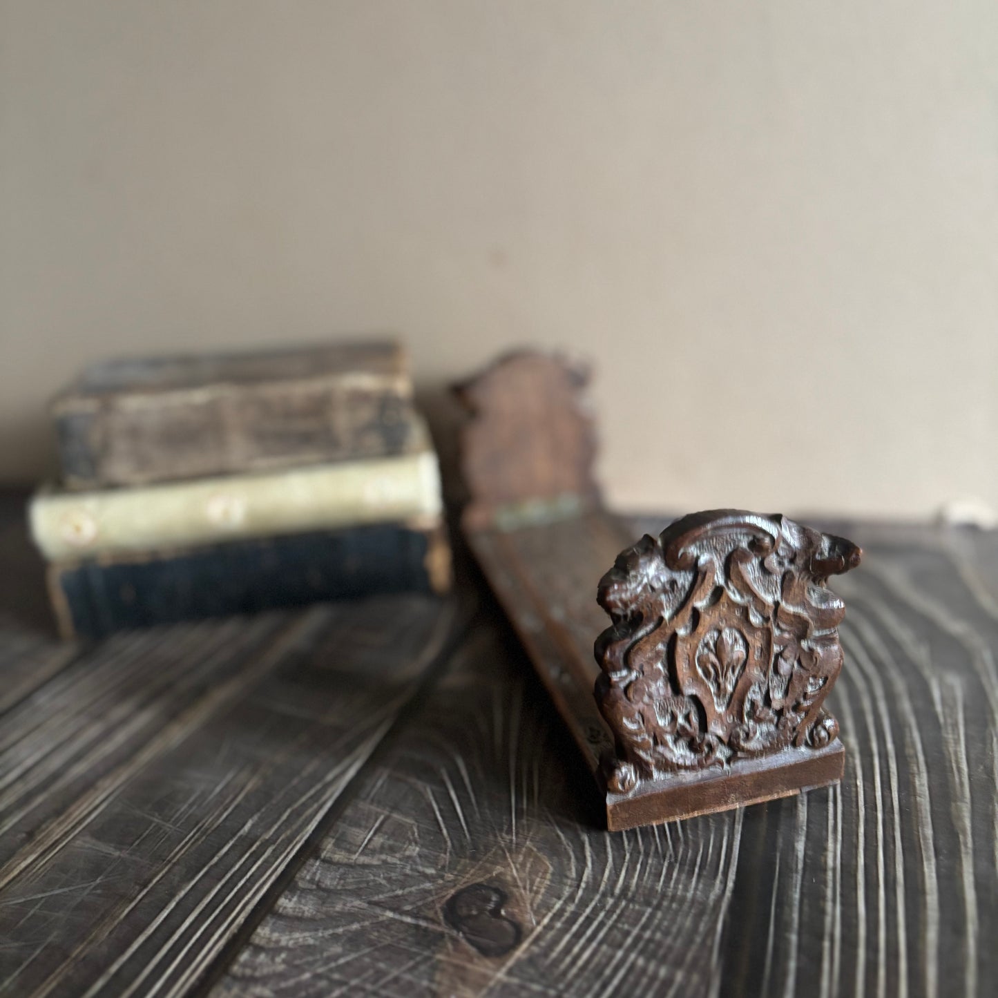 Decorative wooden bracket on a wooden surface with a blurred background