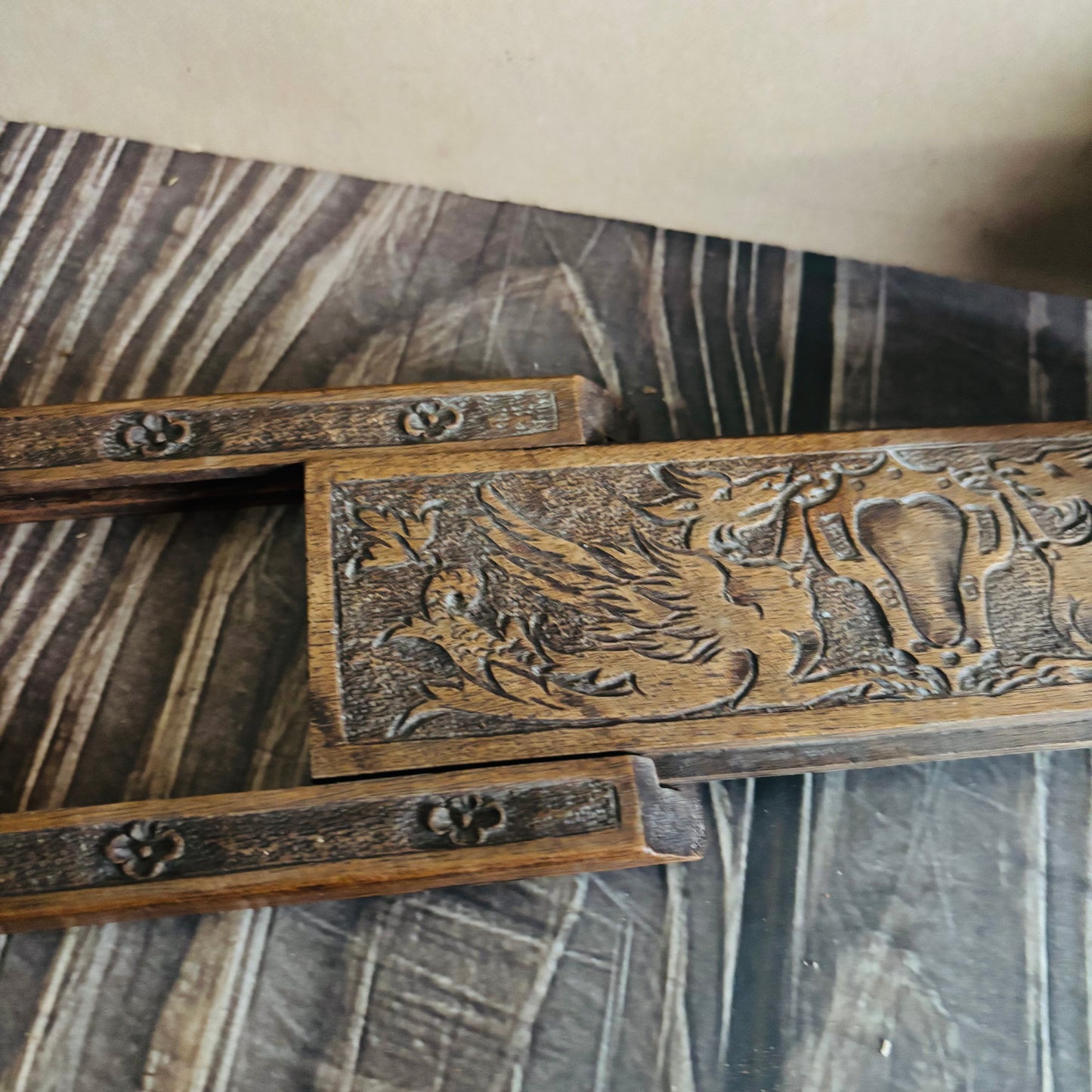 Wooden object with intricate carvings on a textured surface