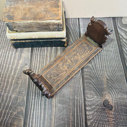 Decorative wooden object with intricate carvings on a textured surface