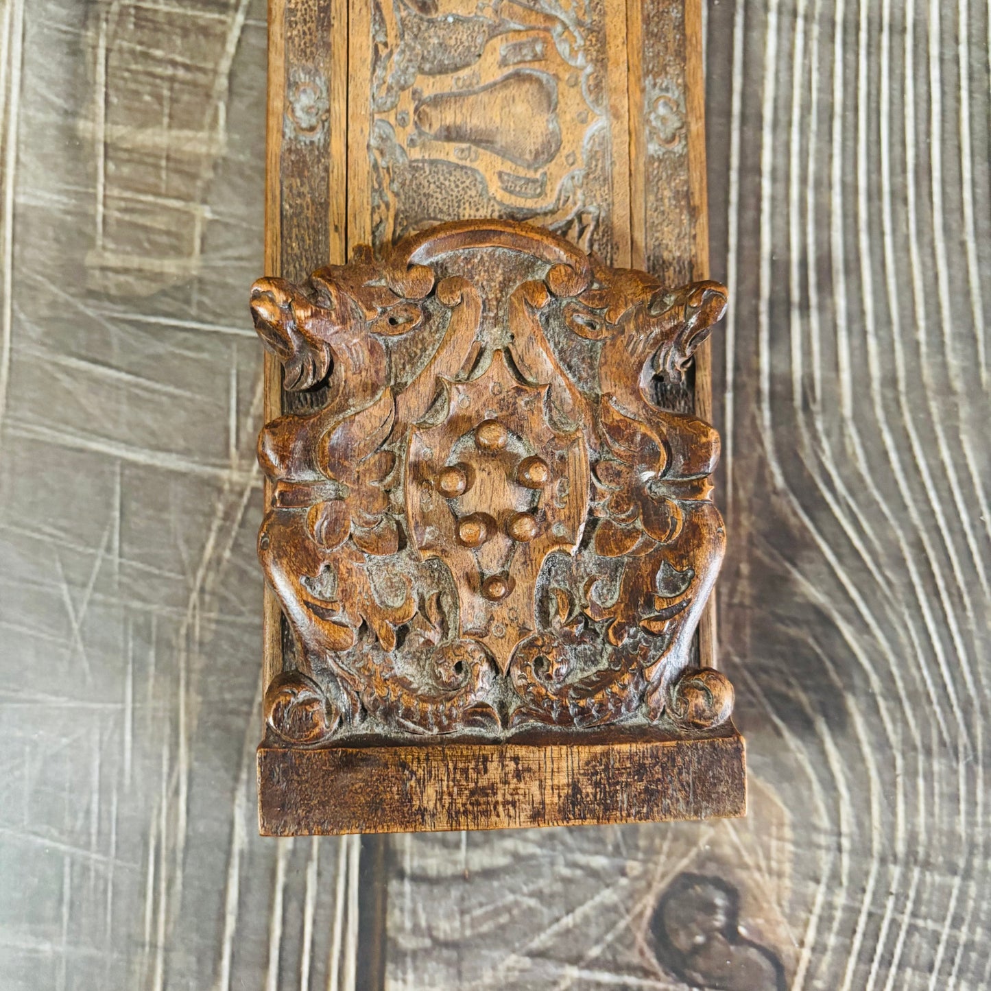 Decorative wooden panel with intricate carvings on a textured background