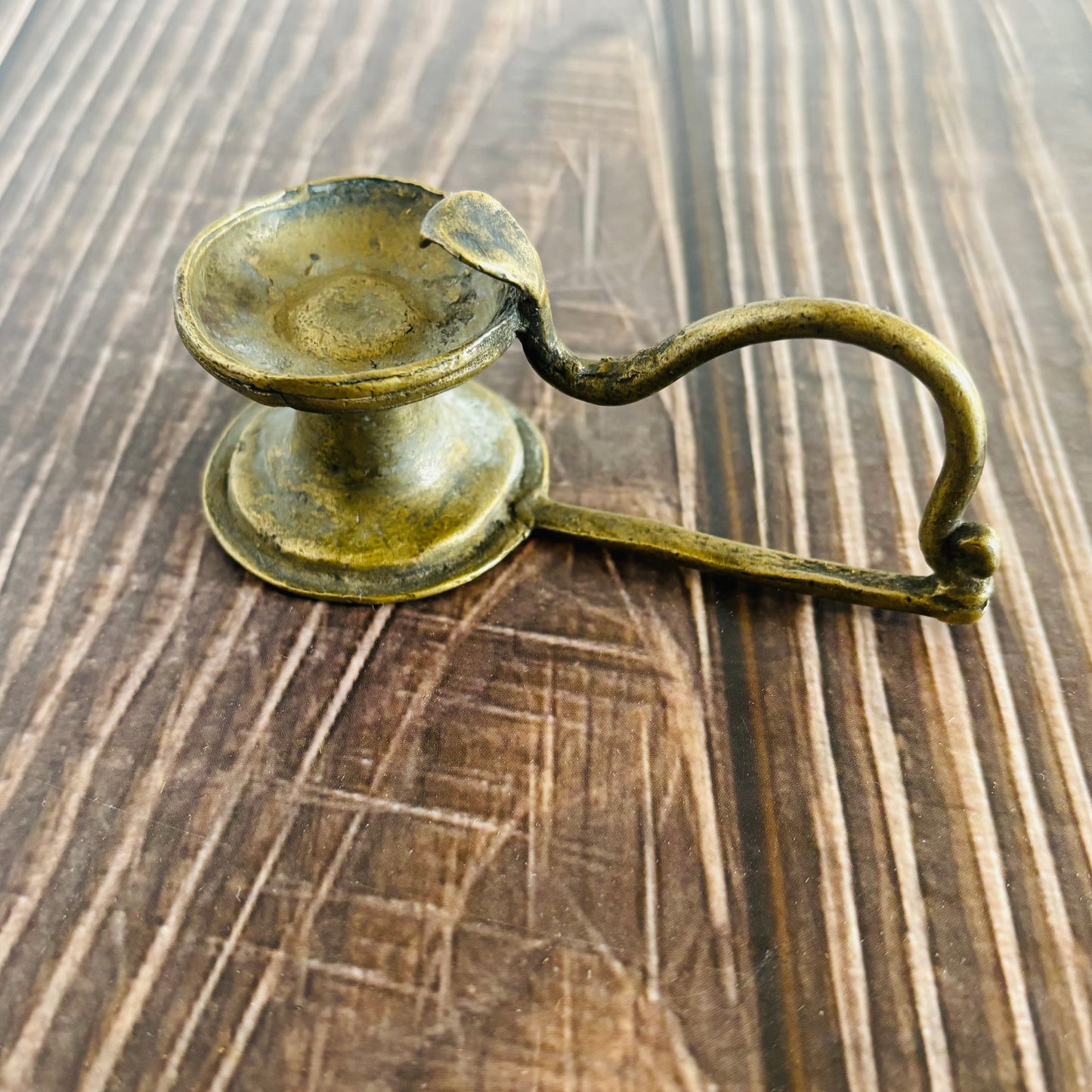 Bronze candle holder on a wooden surface