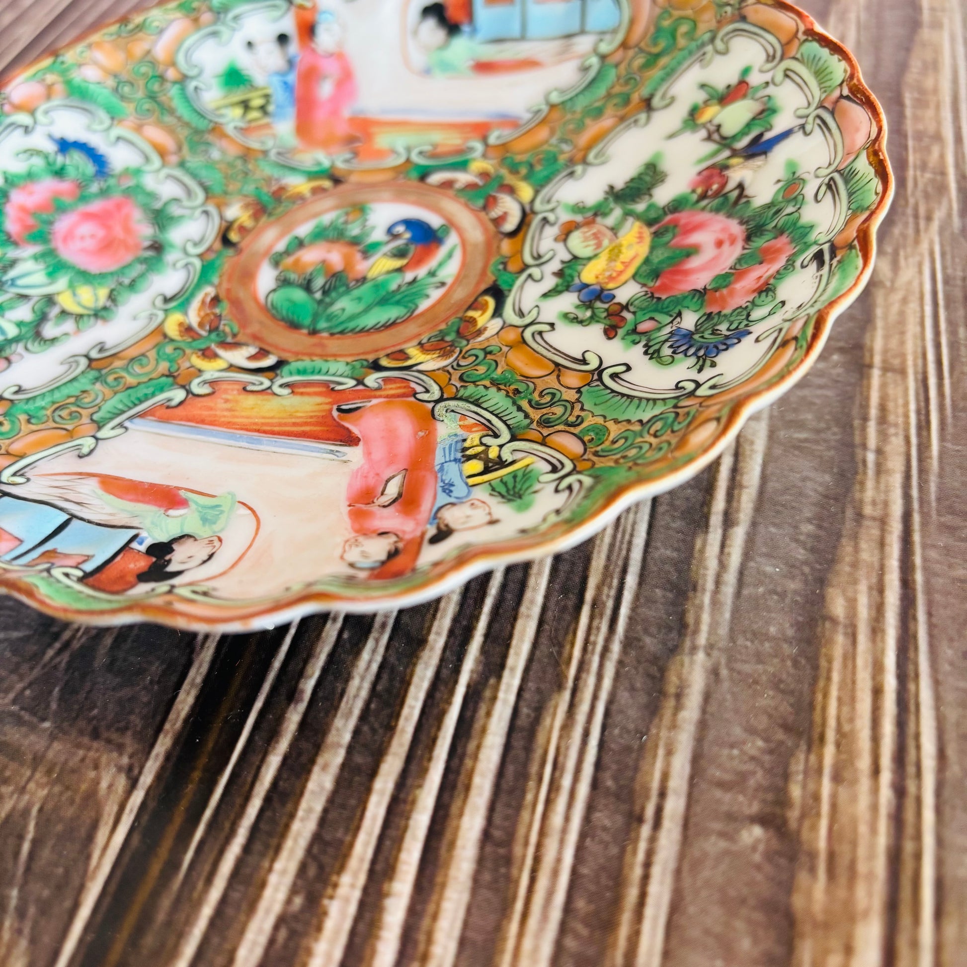 Decorative ceramic plate with colorful animal illustrations on a wooden surface