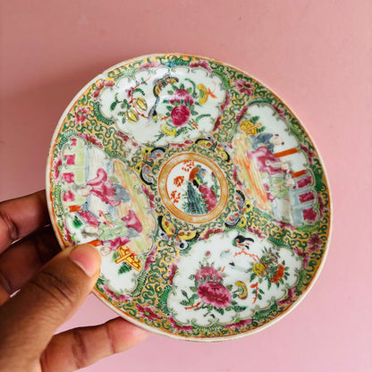 Antique Chinese Rose Medallion Pattern  Saucer with intricate designs held by a hand against a pink background