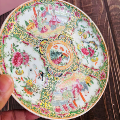 Decorative ceramic plate with intricate floral and animal patterns held by a hand.