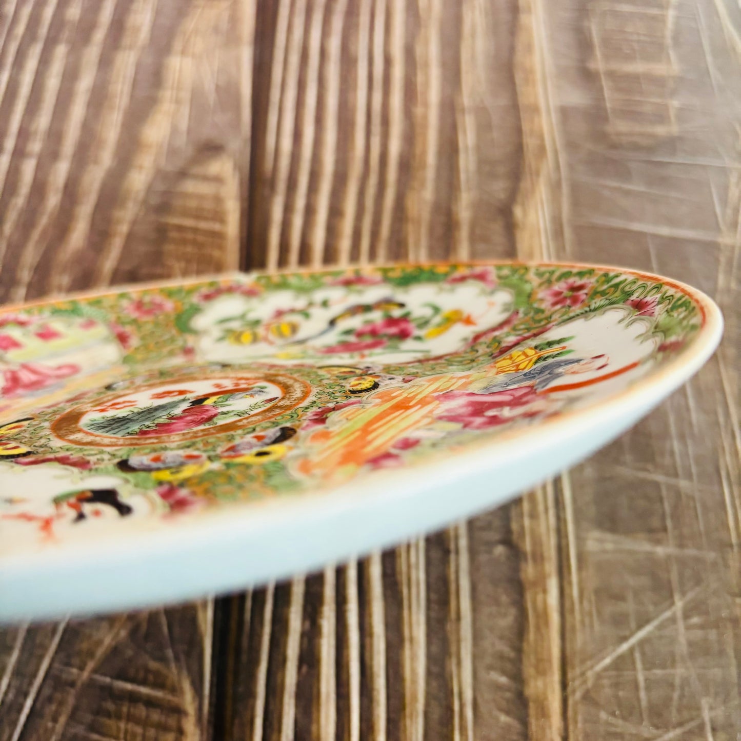 Decorative ceramic plate with colorful patterns on a wooden surface