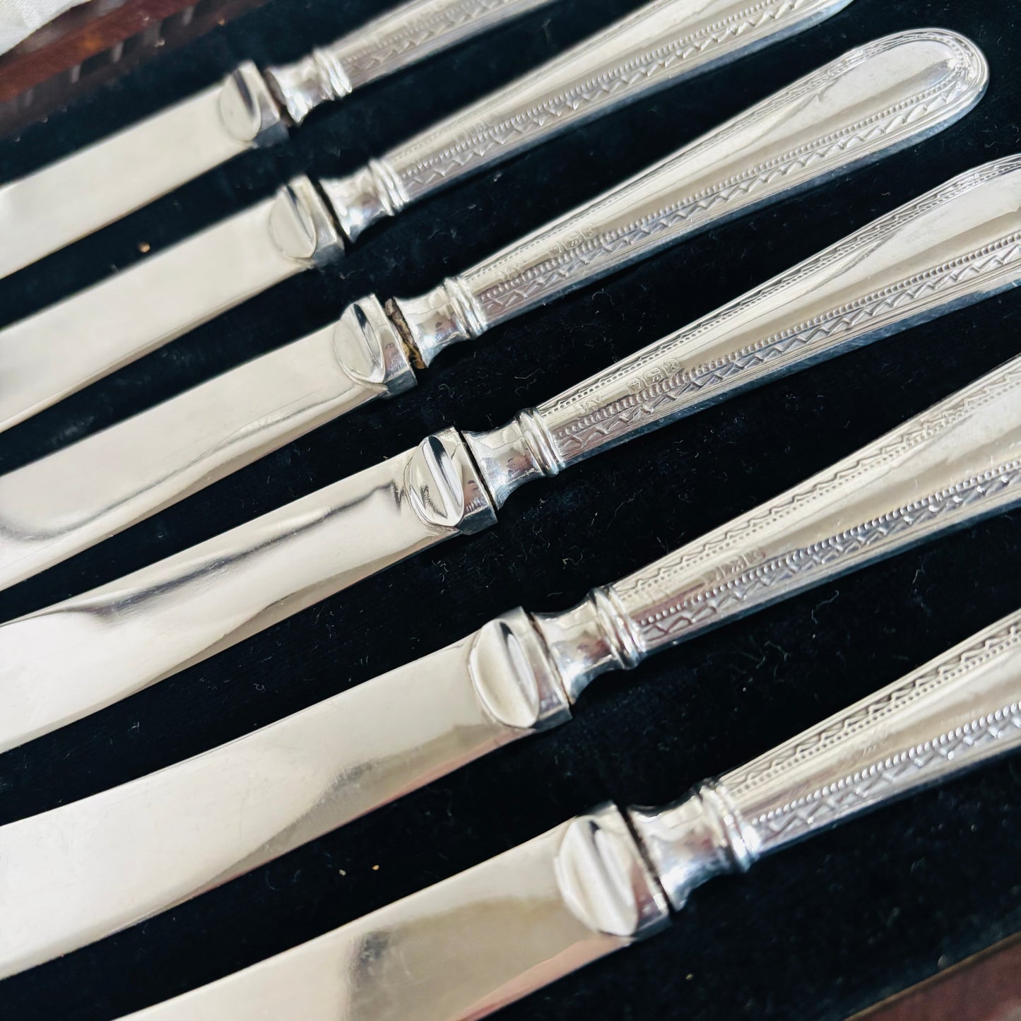 Set of silver tea knives with decorative handles in a case