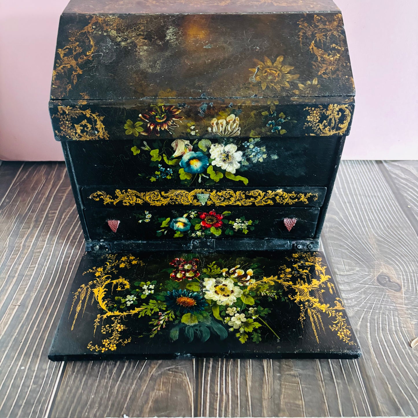 Victorian Paper Mache Lacquer Stationery Box  with hand painted floral patterns on a wooden surface