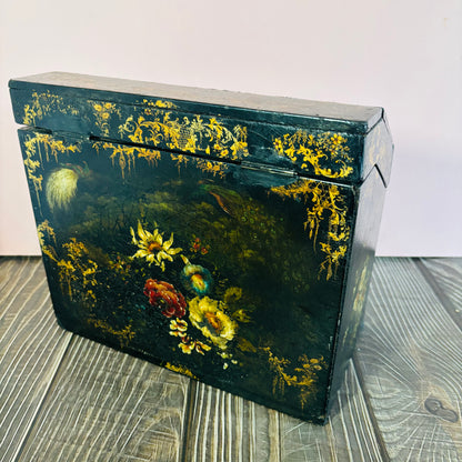 Victorian Paper Mache Lacquer Stationery Box  with hand painted floral patterns on a wooden surface