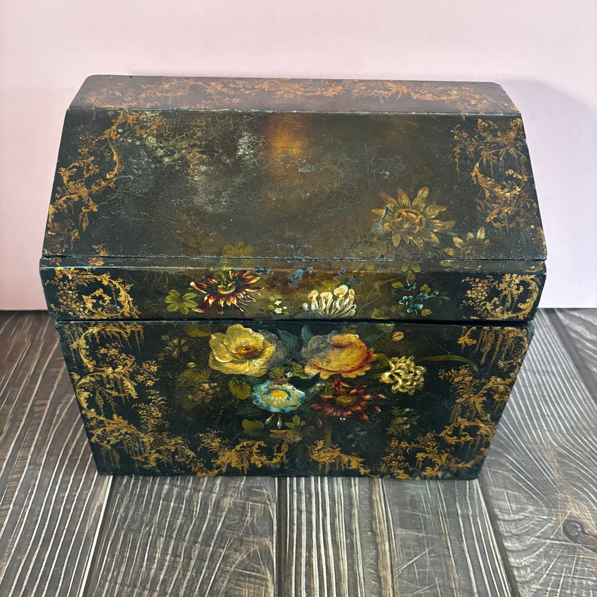 Decorative wooden box with floral patterns on a wooden surface