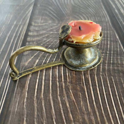Antique Rare Indian Brass Diya Oil Lamp with a candle on a wooden surface
