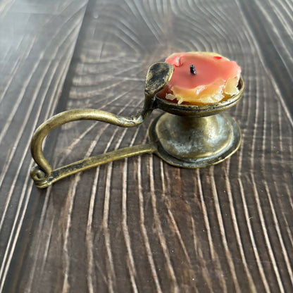 Antique Rare Indian Brass Diya Oil Lamp with a candle on a wooden surface