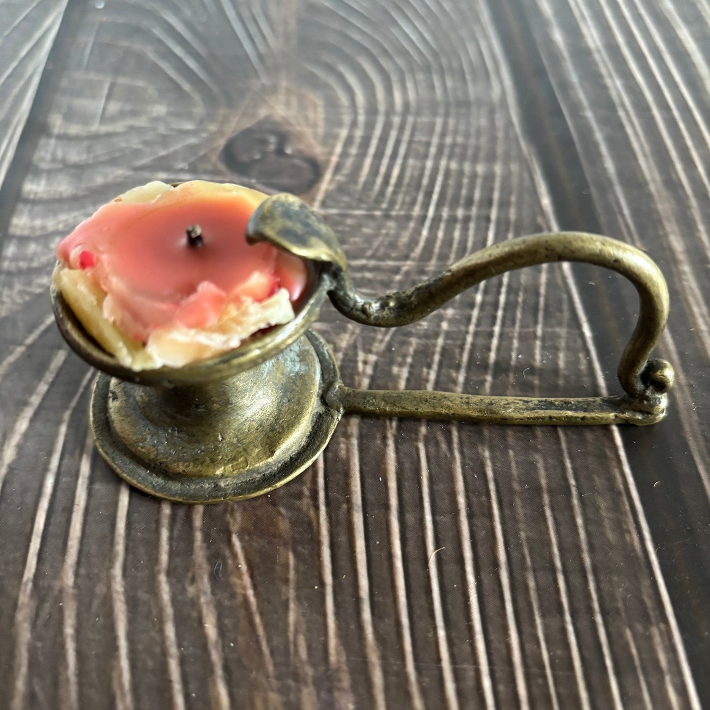 Antique Rare Indian Brass Diya Oil Lamp with a candle on a wooden surface