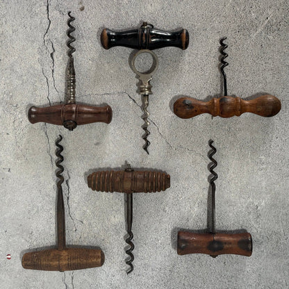 Set of vintage corkscrews on a textured stone wall