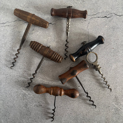 Collection of vintage corkscrews on a textured surface