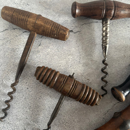 Three vintage corkscrews on a textured surface