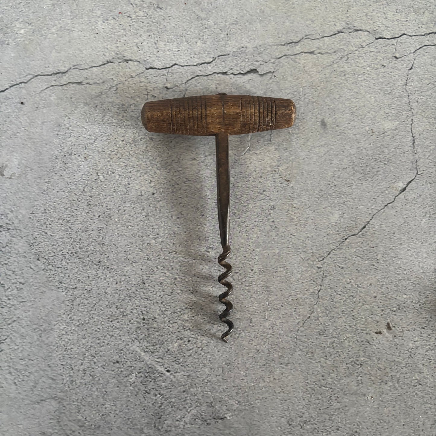 Vintage corkscrew on a textured gray surface