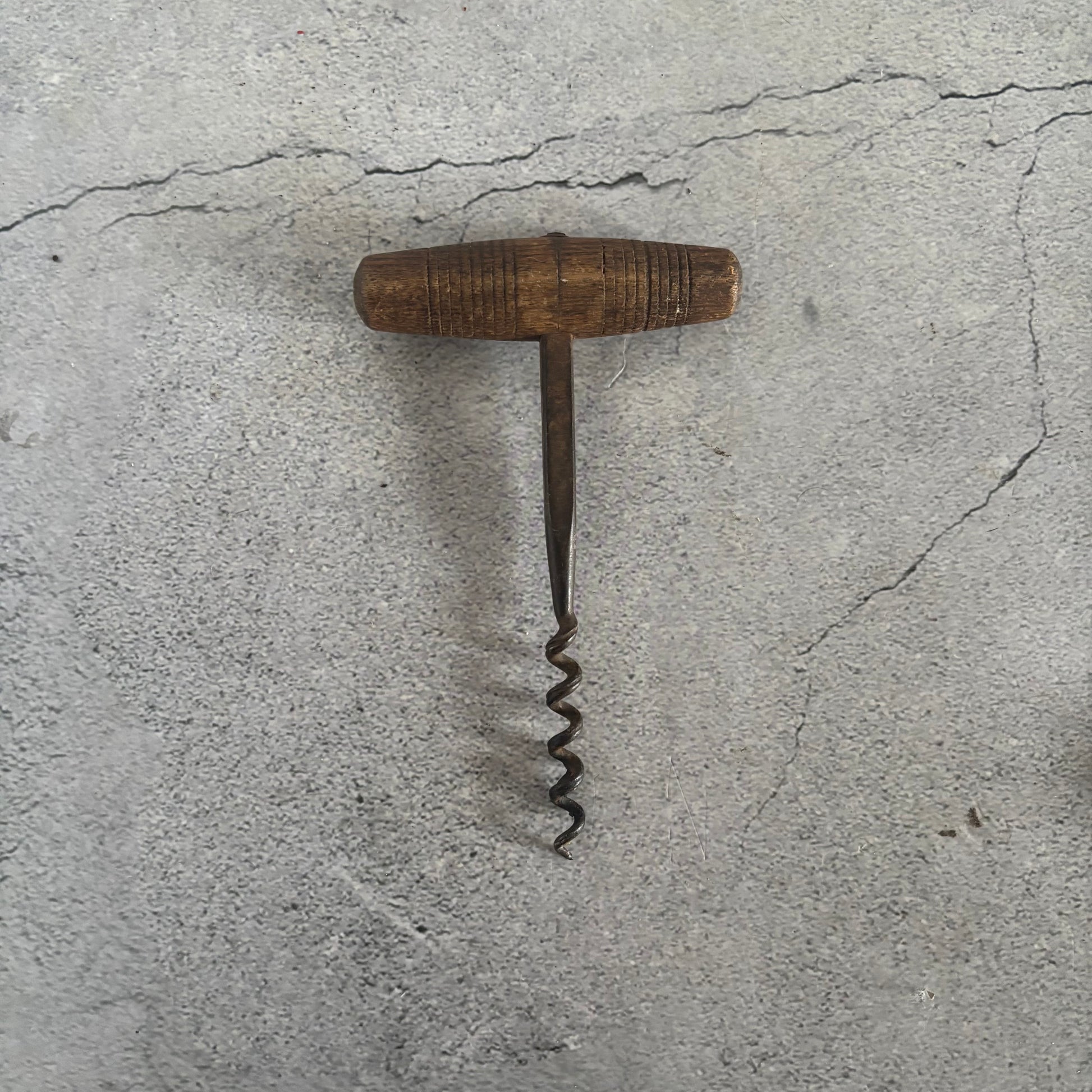Vintage corkscrew on a textured gray surface