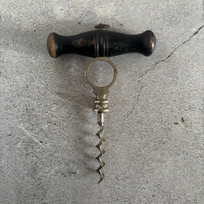 Vintage corkscrew with wooden handle on a concrete surface
