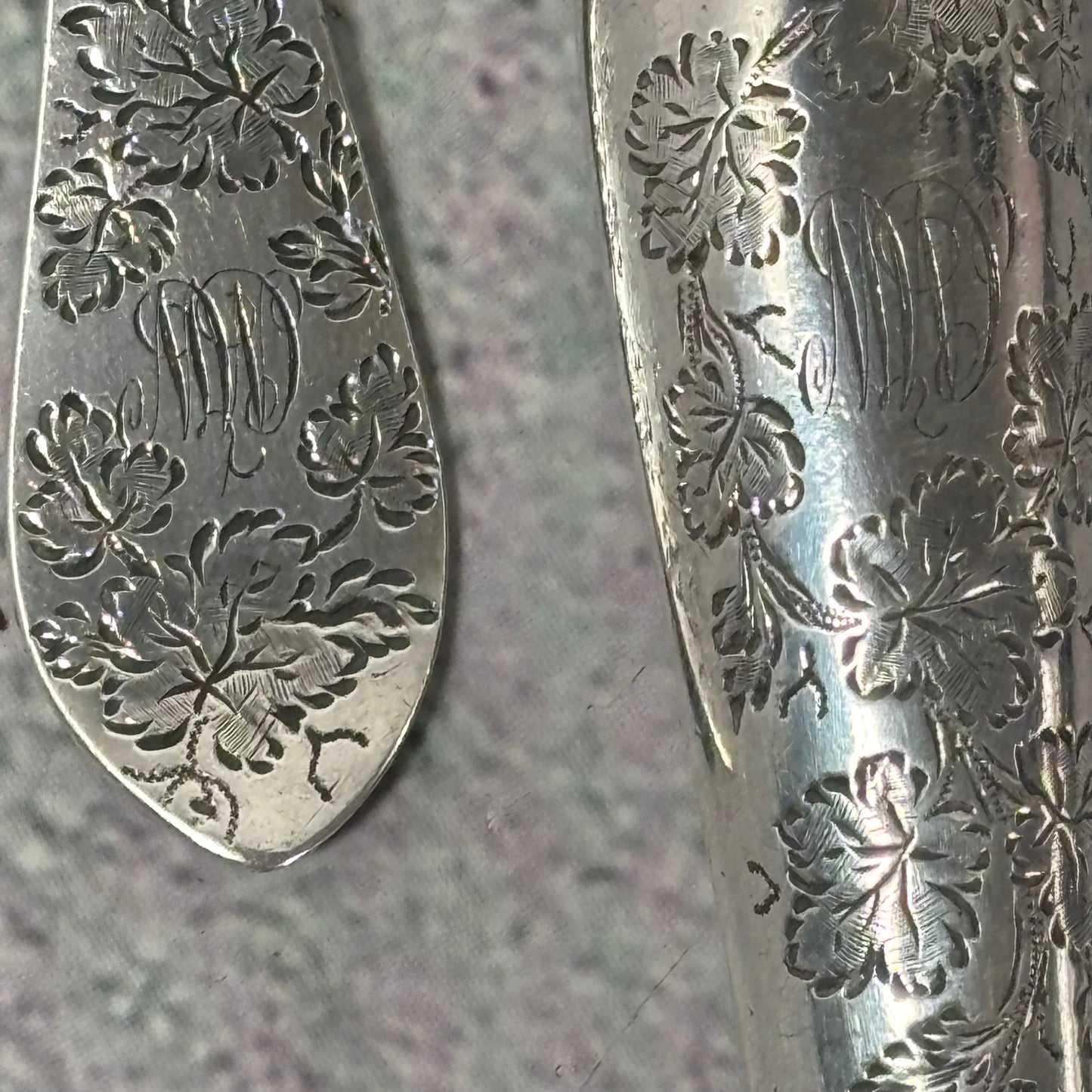 Close-up of Antique Silver Fully Engraved Knife and Fork Duo | 1892 London with intricate floral engravings on a textured surface.
