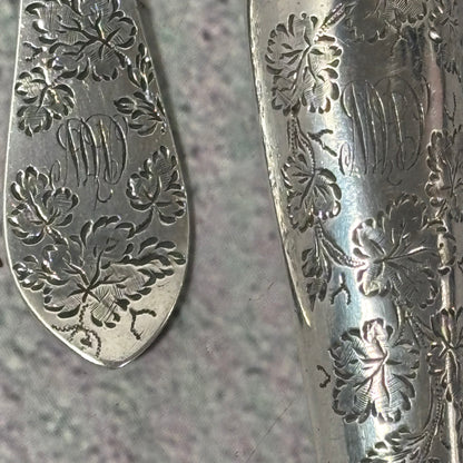 Close-up of Antique Silver Fully Engraved Knife and Fork Duo | 1892 London with intricate floral engravings on a textured surface.