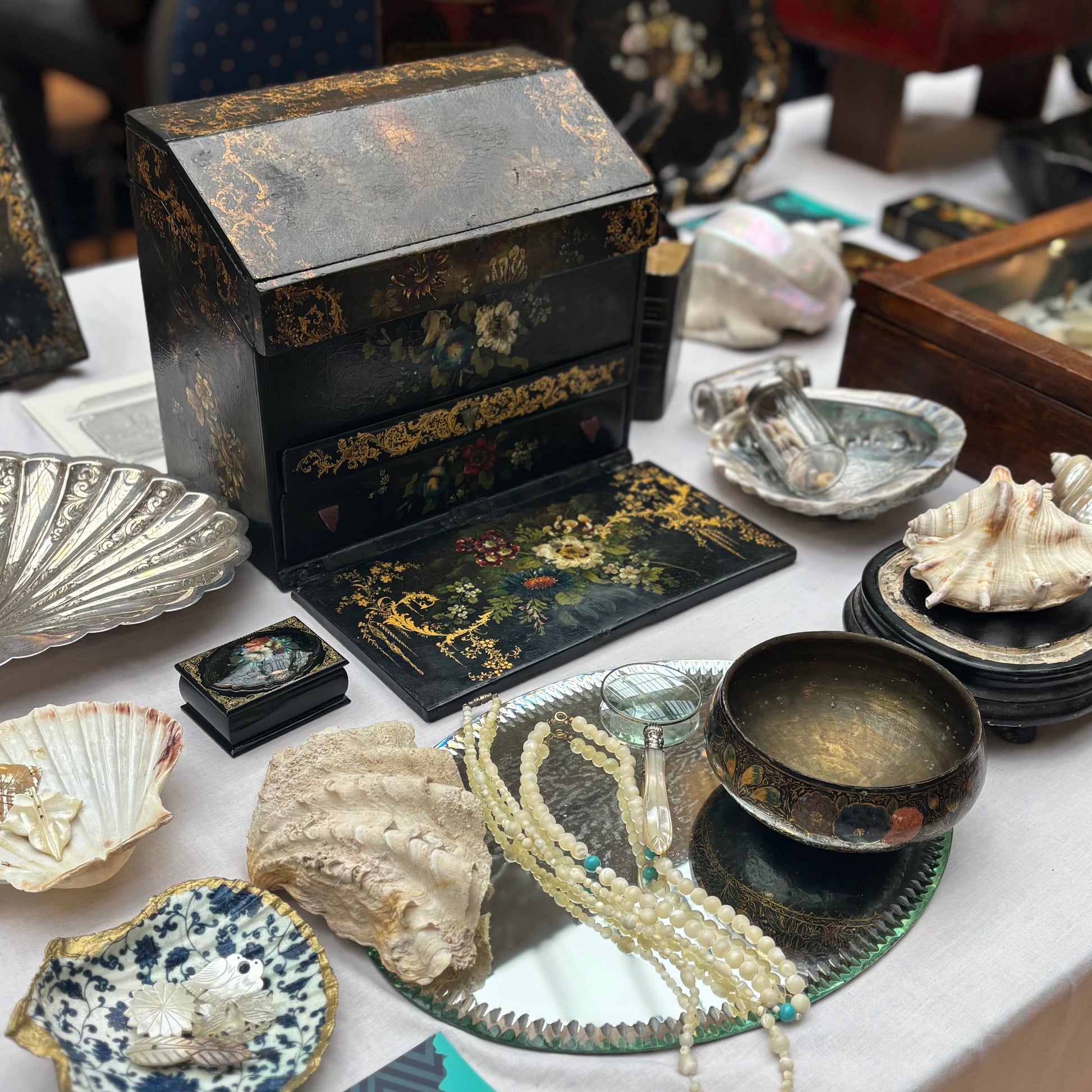 Vintage jewelry and decorative items on a table at a market.