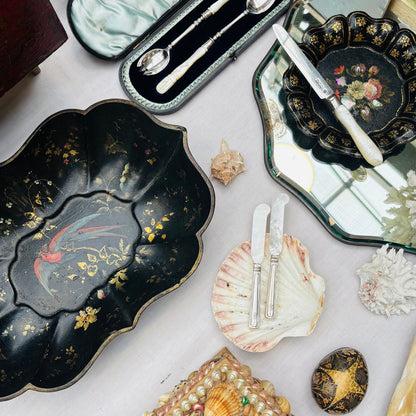 Collection of decorative items including trays, shells, and small boxes on a white surface.