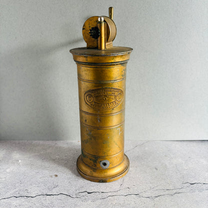 Vintage brass Antique Gynaecological Vaginal Irrigation Pump on a grae surface with a neutral background