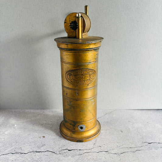 Vintage brass Antique Gynaecological Vaginal Irrigation Pump on a grae surface with a neutral background