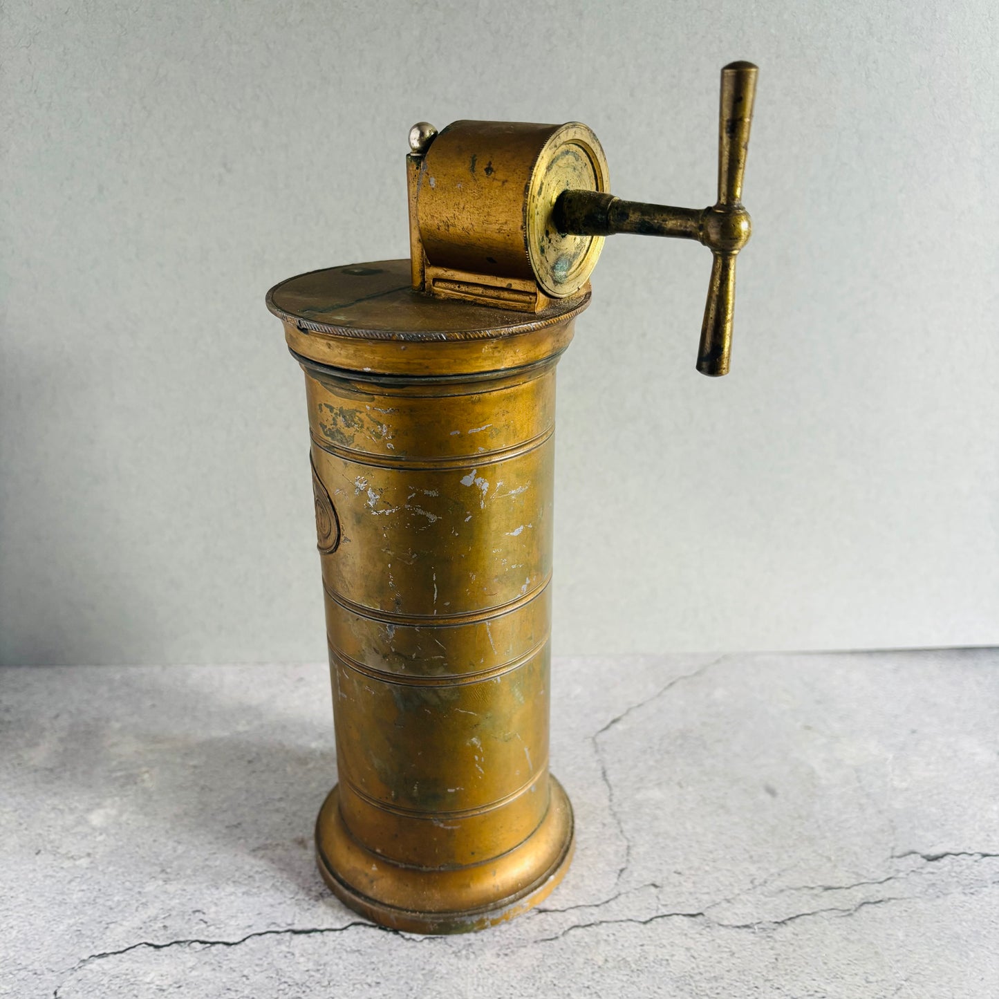 Vintage brass Antique Gynaecological Vaginal Irrigation Pump on a textured gray surface
