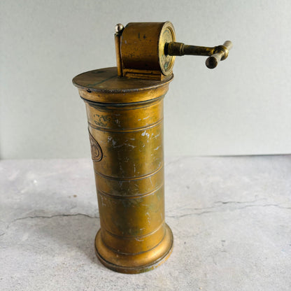 Vintage brass Antique Gynaecological Vaginal Irrigation Pump on a textured surface with a neutral background