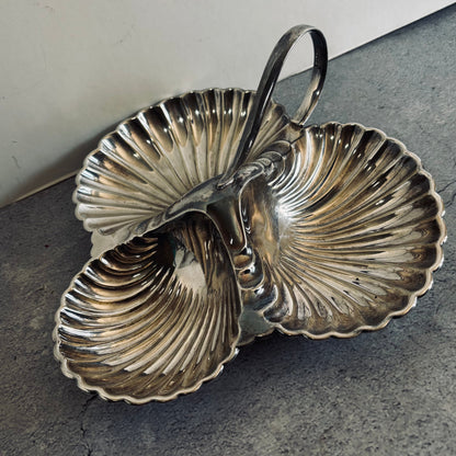 Silver shell-shaped dish on a gray surface