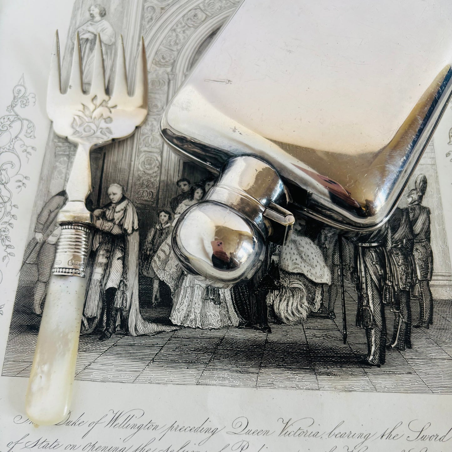 Silver sardine fork with a historical scene in the background