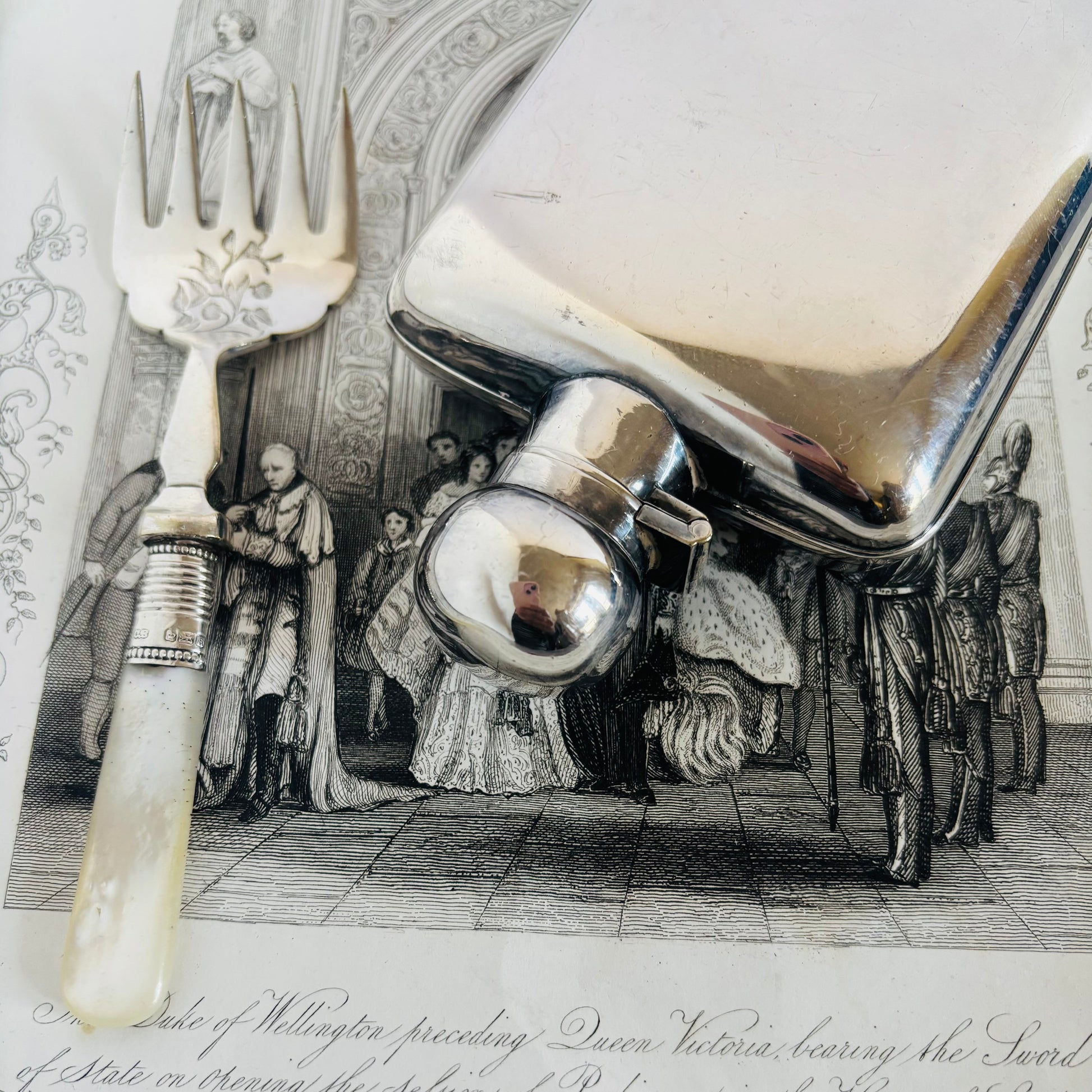 Silver sardine fork with a historical scene in the background