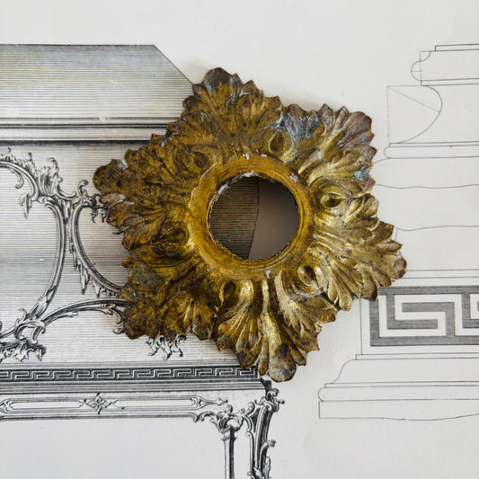 Decorative gold wall piece on a white background with architectural drawings.