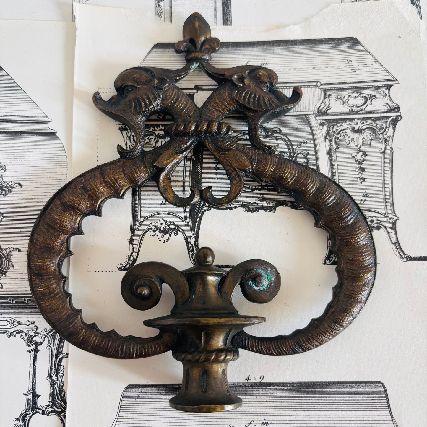 Decorative metal wall piece with intricate design on a vintage architectural background