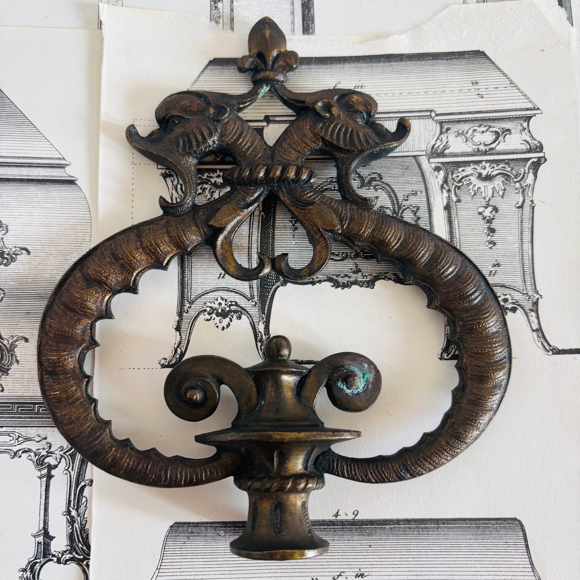 Decorative metal wall piece with intricate design on a vintage architectural background